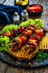 Meat skewers - grilled pork loin, bell pepper and pineapple in teriyaki sauce  on wooden...