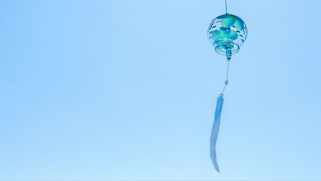 青い風鈴が夏の青空に揺れている　左にスペース