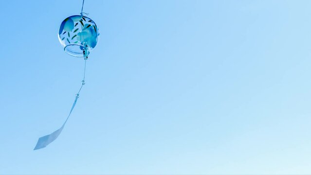 青い風鈴が夏の青空に揺れている　右にスペース