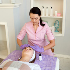 people, beauty, spa, cosmetology and skincare concept - happy young woman with closed eyes getting face massage at spa salon