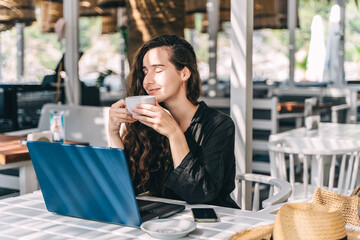 Young woman has rest in summer beach cafe.