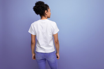 young brunette latin woman in a white t-shirt with a mockup for printing stands with her back