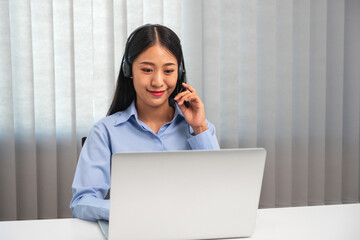 Female call center operator with headset working on support hotline in modern office Teleconferencing via video. online training.