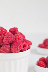 Bowl with fresh organic raspberry on a white background. Copy space.