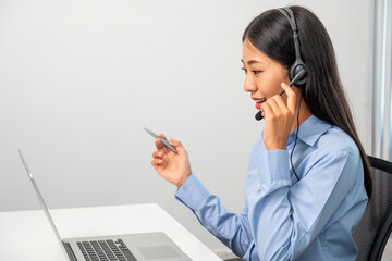 Female call center operator with headset working on support hotline in modern office...