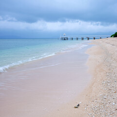 Calm sandy beach and pier in the morning