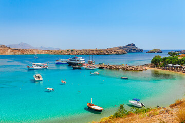 Sea skyview landscape photo Lindos bay and sea coast on Rhodes island, Dodecanese, Greece. Panorama with nice sand beach and clear blue water. Famous tourist destination in South Europe - obrazy, fototapety, plakaty