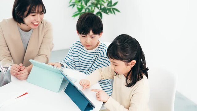 タブレットで勉強する子供たちと教える女性