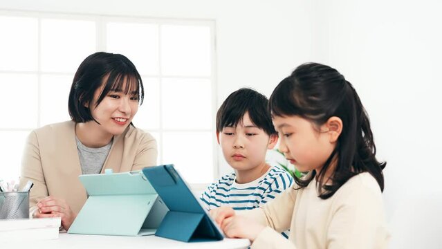 タブレットで勉強する子供たちと教える女性