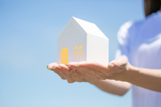 家の模型を持つ女性の手元
