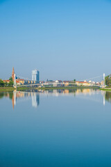 Fototapeta na wymiar Pedestrian bridge over the Drava river and skyline of city of Osijek, Croatia