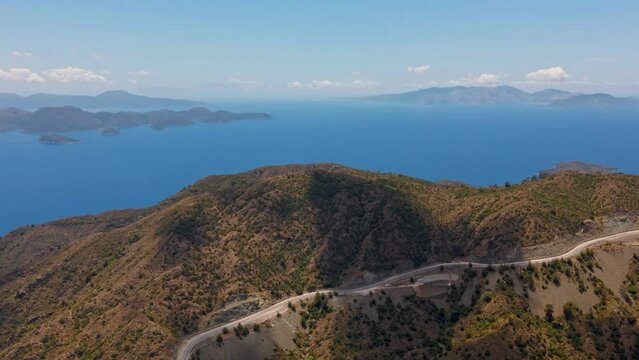 aerial drone footage of beautiful scenic landscape of Marmaris peninsula, mountains and hills with green woods and curved road to Datca destination. peninsula surrounded Aegian and Mediterranean seas.