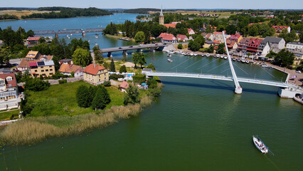 Panoramic aerial photo from drone to Mikolajki townscape - capital of Masurian region on the shore of the holiday resort beautiful summer afternoon. Mikolajki, Mikołajki, Poland, Europe.