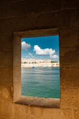view through the window of an old fortress on the old town and the harbor
