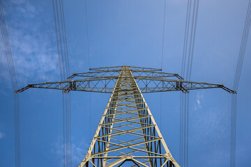 Ein Strommast für Freileitung Ansicht von unten in den blauen Himmel
