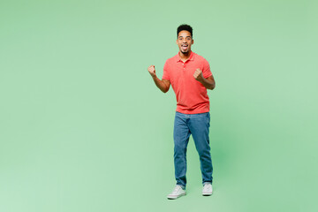 Full body fun young man of African American ethnicity he wears pink t-shirt doing winner gesture...