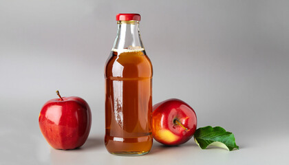 Apple cider bottle and red apples on light gray background