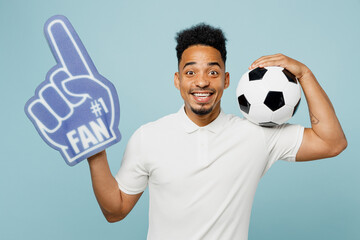 Young excited man fan wear basic t-shirt foam 1 fan glove finger up cheer up support football sport...
