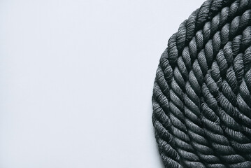 Close up of black battle rope on a gray backgound. Sport and fitness equipment