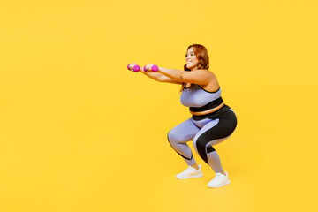 Fototapeta na wymiar Full body side view young chubby plus size big fat fit woman wear blue top warm up training hold dumbbells do squat lunges isolated on plain yellow background studio home gym. Workout sport concept.