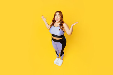 Fototapeta na wymiar Full body top view from above happy young chubby plus size big fat fit woman wears blue top warm up training stand on scales isolated on plain yellow background studio home gym. Workout sport concept.