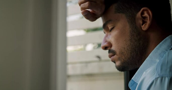 businessman is standing by the window depressed and stressed with problems in his life.