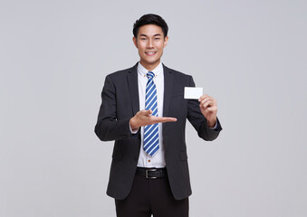 happy smiling young Asian businessman showing credit card isolated on white studio background....