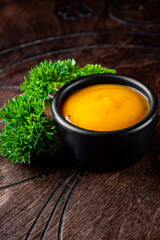 Fresh homemade organic mustard sauce in bowl on wooden background