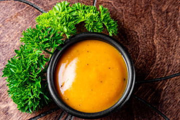 Fresh homemade organic mustard sauce in bowl on wooden background