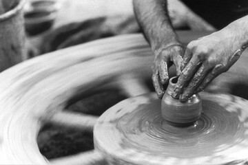 old vintage 1900s black and white picture of Indian potter on potters wheel making clay pot India