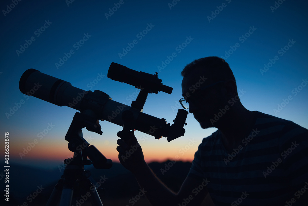 Canvas Prints astronomer looking at the starry skies and crescent moon with a telescope.