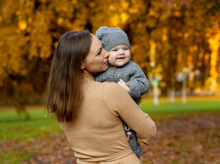 Mom with her daughter in her arms in the park in autumn