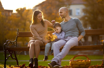 Beautiful young couple with son enjoying a warm autumn day