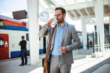 Businessman commuting in the city. Business person is waiting for train and drinking coffee....