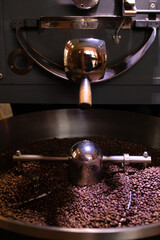 process of preparing, roasting fresh raw coffee beans grain in coffee roaster professional machine. soft focus.  vertical