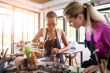 Teacher jeweler and student make jewelry in workshop