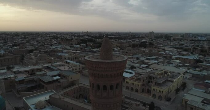 A drone flies around the famous memorial complex Kalyan Poi Kalon Complex and Poi Kalon Minaret, Poi Kalan or Po-i-Kalyan in Bukhara at dawn