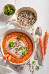 Red carrot soup with sunflower seeds and parsley.
