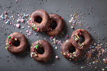 Dark brownie donuts with chocolate topping and sprinkles.