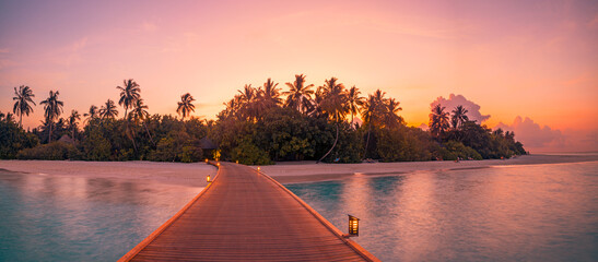 Sunset on Maldives island, luxury water villas resort, wooden pier. Beautiful sky clouds and beach...