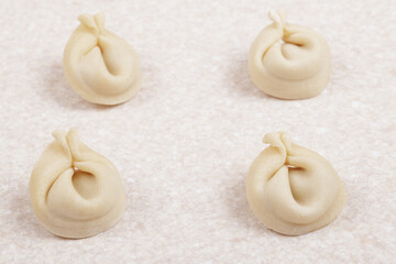 Uncooked dumplings on white table closeup. Homemade dumplings.