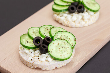 Rice Cake Sandwiches with Fresh Cucumber, Cottage Cheese and Olives on Cutting Board. Easy...