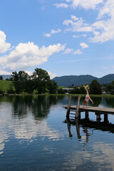 Summer, holidays. A girl swims in a lake in the mountains in Austria. Holidays in Austria