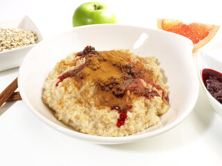 Porridge in a white Bowl; Oatmeal with Berrys an Cinnamon isolated on white Background