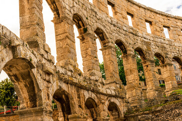 arc wall of ancient building in arena colosseum style, typical roman architecture with arches, windows and vintage yellow facade