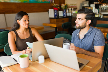 Beautiful couple at the coffee shop doing remote work