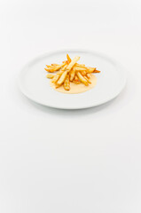 immagine primo piano di croccanti patatine fritte con salsa piccante su piatto in porcellana bianco su superficie bianca
