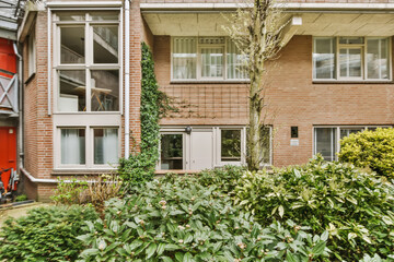 Fototapeta na wymiar an apartment building with plants and bushes in the foregrounds, berlin, germany - stock photos & video footage
