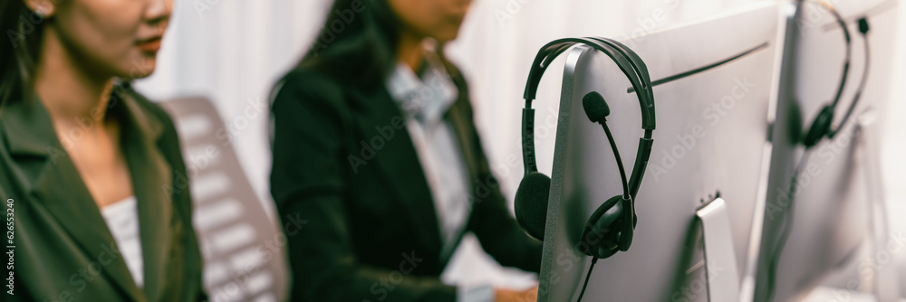 Aufkleber panorama focus headset on call center workspace desk with blur background of operator team or telesa