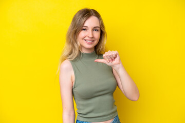 Blonde English young girl isolated on yellow background proud and self-satisfied